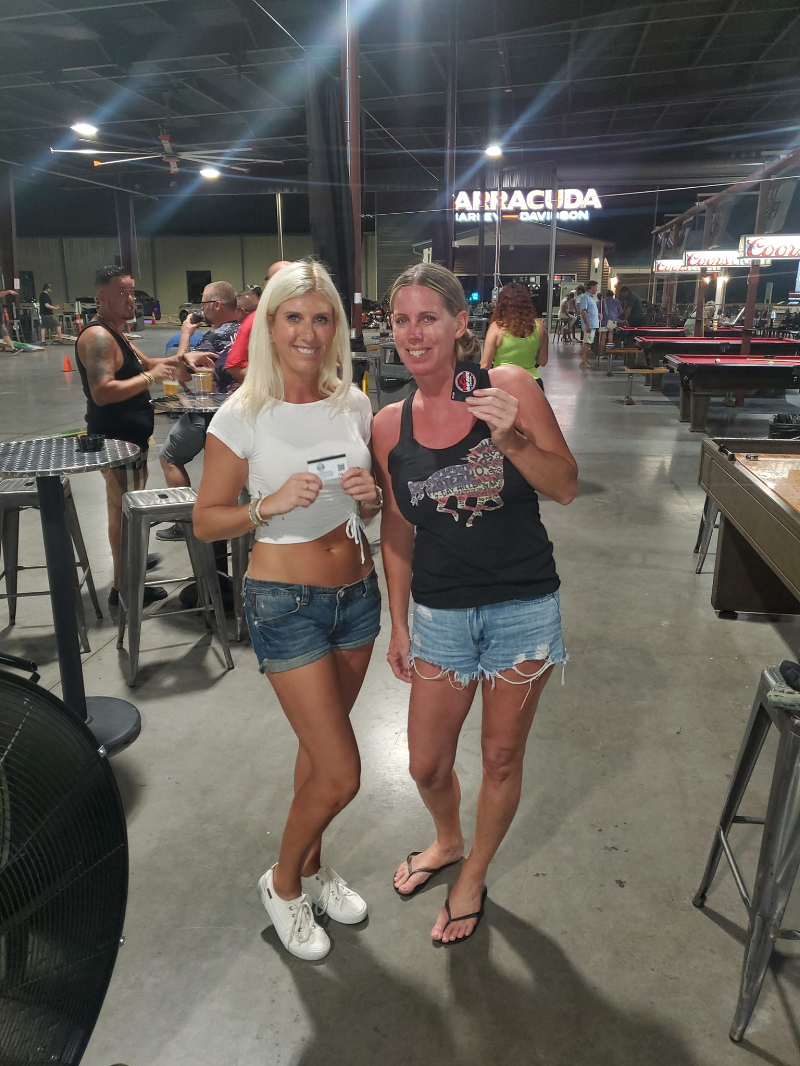two women holding up OCC Road House gift cards