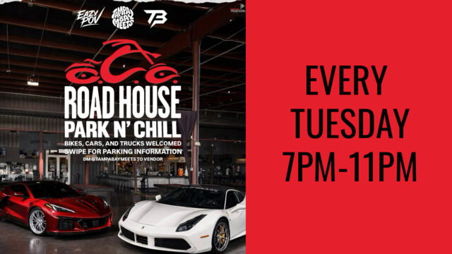 Two sports cars are parked inside an industrial-style building with a sign advertising 