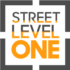 Logo with the words “STREET LEVEL ONE” in gray and orange bold text, surrounded by four gray right-angle corners forming a border.