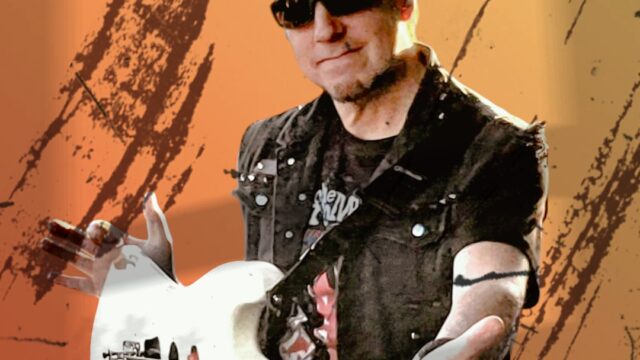 A man wearing sunglasses holds a white electric guitar against an orange, textured background.